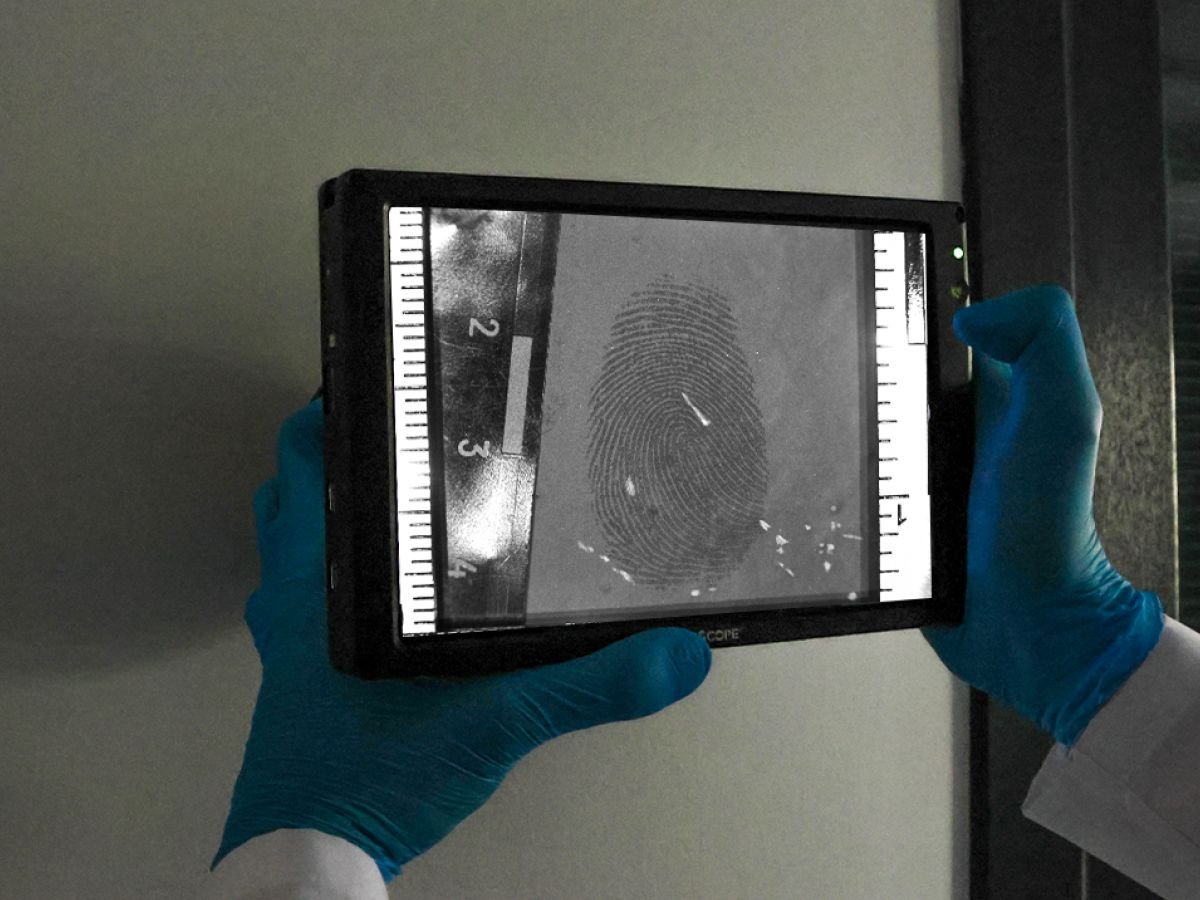 Expert en criminalistique identifiant des empreintes digitales latentes à l'aide de la tablette de détection haute résolution 8K.